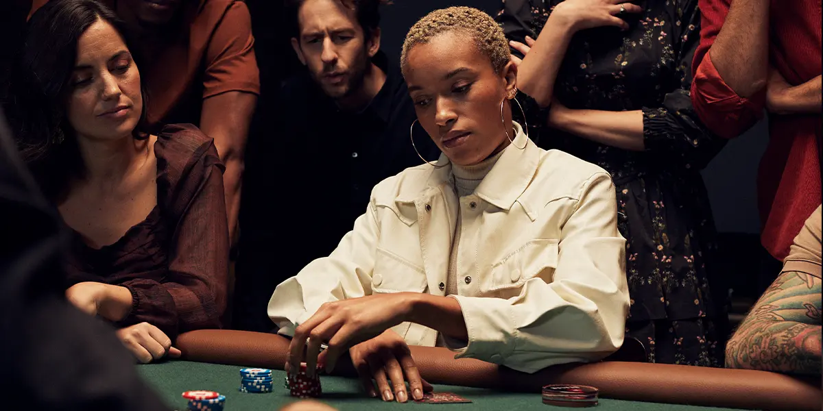 Ein Pokerspieler denkt über seinen nächsten Zug nach, nachdem er viel Aggression erlebt. Dies veranschaulicht, wie schwer ein Fold mental ist, wenn du viele Chips investiert hast.